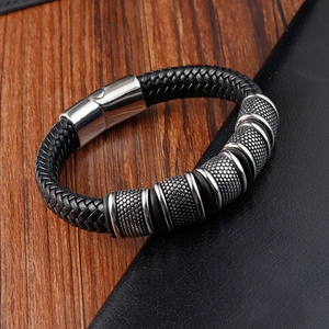 Macro shot of black braided leather bracelet featuring stainless steel textured beads