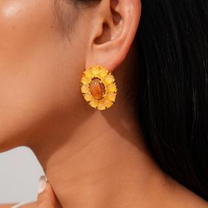 Detalle de pendientes ovalados retro con cuentas naranjas usados por una modelo real