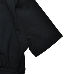 Close-up of black V-neck bodysuit showing short sleeve fabric texture and side pleats