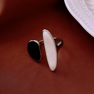 Close-up of leopard oil drip open ring with black and white oval enamel on silver metal