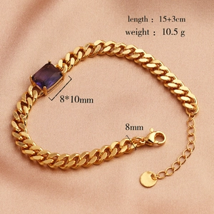 Gold Cuban link bracelet with a purple rectangular zircon stone on pink silk fabric