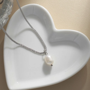 Baroque freshwater pearl pendant on silver chain inside a heart ceramic dish