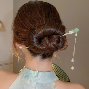 Vue détaillée du pic à cheveux chinois avec fleur de jade, gland et perle sur coiffure qipao