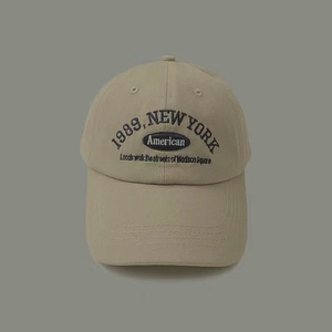 Detailed close-up of 1989 New York embroidery on beige vintage cotton baseball cap
