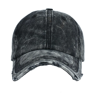 Close-up of distressed denim baseball cap showing washed cotton texture and frayed brim details