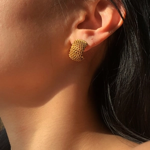INS style textured 18k gold mesh earrings in stainless steel on a female model