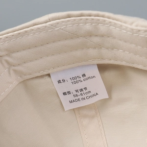 Detailed macro view of the inner 100% cotton lining and washing label of the duck cap