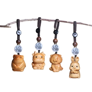 Handcrafted wooden zodiac keychains featuring rat, ox, tiger, and rabbit carving designs