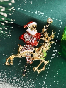 Macro shot of Santa Claus riding a reindeer brooch with rhinestones and size details