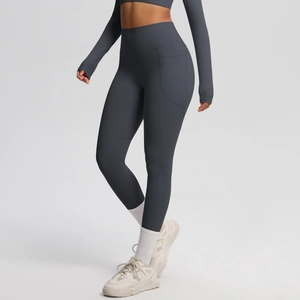 Detail of high-waisted gray yoga leggings with side pockets and slimming elastic fabric