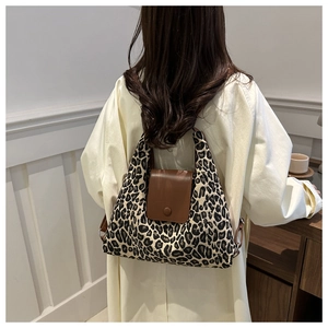 Leopard print tote bag detail showing brown leather flap on a stylish canvas shoulder bag