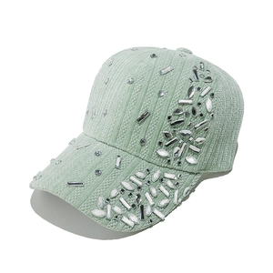 Close-up of mint green velvet baseball cap with sparkling crystal rhinestones and texture