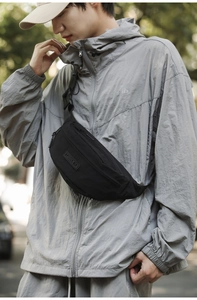 Close-up of black crossbody chest bag showing nylon fabric texture and metal zipper
