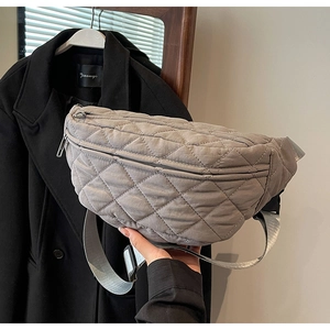 Detailed view of grey quilted diamond pattern chest bag with adjustable wide strap