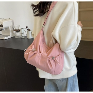 Pink nylon shoulder bag featuring drawstring side pleats and silver metallic hardware