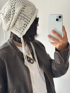 Détail du bonnet au crochet blanc montrant des motifs tricotés géométriques et des liens