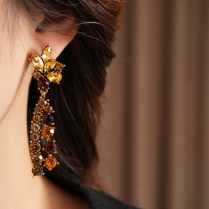 Makroaufnahme von Vintage-Ohrringen in Goldoptik mit bernsteinfarbenen Strass-Quasten