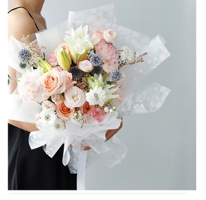 Détail du papier d'emballage translucide à motif flocon sur un bouquet de fleurs