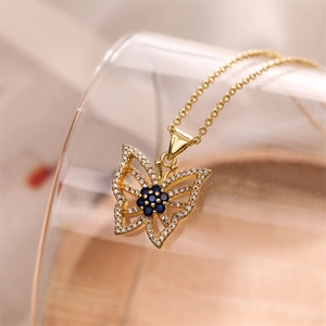 Macro view of gold butterfly pendant with deep blue gemstone and sparkling crystals