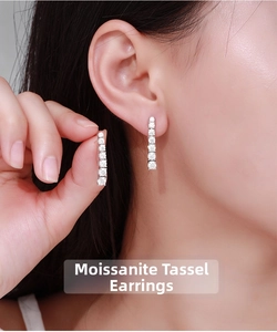 Macro view of moissanite tassel earrings featuring vertical drop diamonds in silver setting