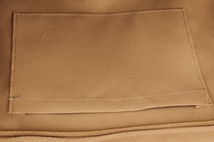 Close-up of brown canvas bag interior with inner pocket and durable zipper detail