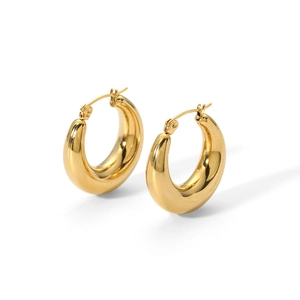 Macro detail of thick 18k gold C-shaped hoop earrings with a polished metallic finish