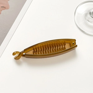 Close-up of amber jelly banana hair clip with inner teeth on a clean white background
