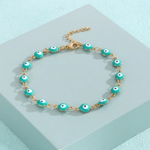 Detail eines 18K vergoldeten Evil Eye Armbands mit blauem Emaille auf geometrischem Block