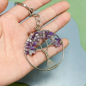 Detail of handmade silver wire tree of life keychain with purple amethyst natural stones