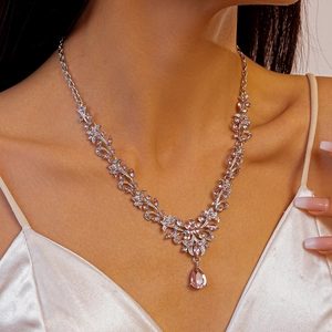 Detailed close-up of a silver leaf necklace featuring pink zircons and a teardrop pendant