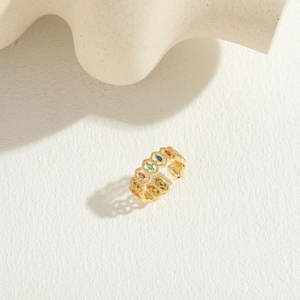 Detailed view of hollow design gold ring with colorful oval zircon gemstones