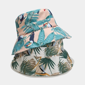Tropical print foldable sun hats featuring palm leaves and toucan patterns for women
