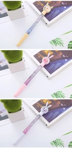 Close-up of glitter pens featuring cartoon deer and bunny designs with liquid sand barrels