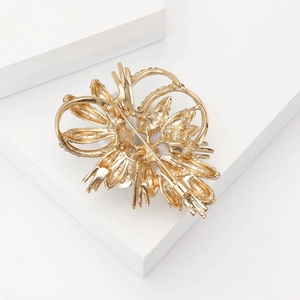 Detailed back view of a gold floral brooch showing the pin mechanism and metal texture