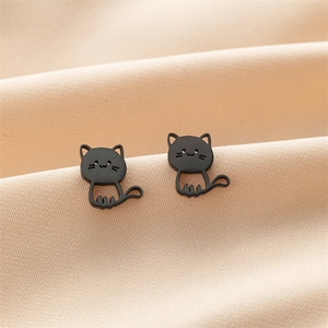 Detailed close-up of matte black stainless steel cat-shaped stud earrings on soft fabric