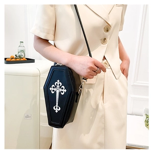 Macro detail of gothic coffin-shaped crossbody bag with white cross print and leather texture