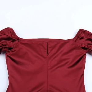Dettaglio dell'abito in raso rosso vino con zip invisibile e maniche a sbuffo eleganti