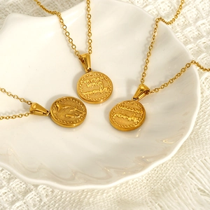 Three gold lily of the valley flower coin necklaces displayed on a shell tray