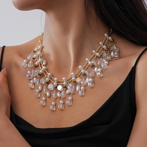 Close-up of vintage tassel necklace with gold chains, clear crystals and white pearls