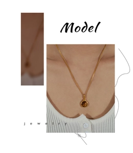 Détail artistique d'un collier pendentif en pierre oeil de tigre doré sur un mannequin