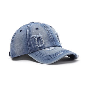 Distressed light blue washed denim baseball cap with vintage ripped details and curved brim