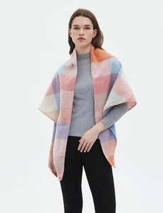 Close-up of knit plaid scarf in pink, blue and orange tones on female model