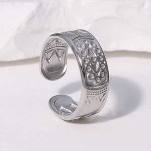 Close-up of silver adjustable ring featuring intricate tribal totem carvings on wide band
