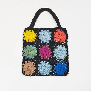 Close-up of handmade crochet tote bag with colorful granny square floral patterns