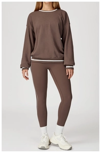 Detail of dark brown sweatshirt with white striped edges and matching activewear pants