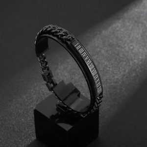 Macro shot of matte black stainless steel bracelet with Roman numeral engraving on bar