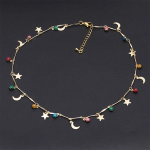 Detail showing golden star and moon pendants with colorful beads on a fine choker chain