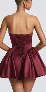 Detail of burgundy satin dress showing the lace-up back design and smooth fabric