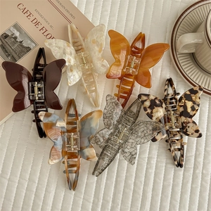 Elegant butterfly acetate hair claws in various patterns on a French style background