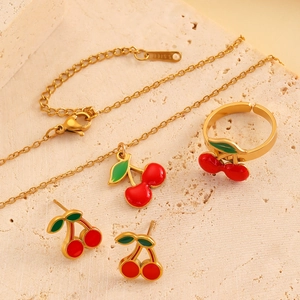 Détail d'un ensemble de bijoux cerise en acier inoxydable doré avec collier et bague